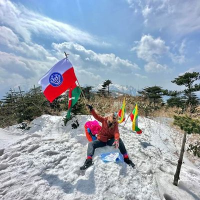 အမြင့်ပေ ၁၁၉၀၀ ကျော်ရှိသည့် ဖုန်ကန်ရာဇီတောင်ထိပ်တွင် ရခိုင်အမျိုးသမီးတစ်ဦးက ရခိုင်အလံလွှင့်ထူ